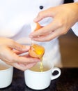 Baker, hands and separate eggs for yolk, white and preparation for cooking, dessert or meal in kitchen job. Professional