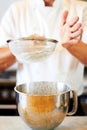 Baker hands, sifting flour and baking skill, cake or pastry with metal bowl closeup, dessert and person in bakery