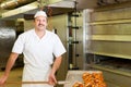 Baker in his bakery baking bread Royalty Free Stock Photo