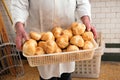 Baker holding a basketful of freshly baked rolls