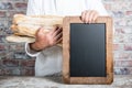 Baker holding bread french baguettes with chalkboard Royalty Free Stock Photo