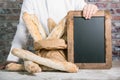 Baker holding bread french baguettes with chalkboard Royalty Free Stock Photo