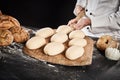 Baker holding a wooden paddle with formed dough