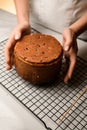 Baker holds the Easter cake in his hands, which is lying on the rack Royalty Free Stock Photo