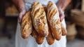 Baker holds fresh baked French baguettes. Homemade sourdough bread Royalty Free Stock Photo