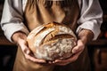 baker holds fresh, fragrant, delicious bread in his hand