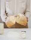 Baker holds in his hands a freshly baked sourdough bread, broken in half Royalty Free Stock Photo