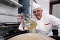 Baker at home with a hand blender making pastry cream