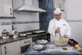 Baker in a home kitchen with a hand blender making pastry cream