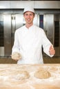 Baker kneading dough in bakery or bakehouse Royalty Free Stock Photo