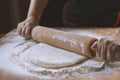 Baker pours flour for making pizza. Chef cooking dough to bake a cake on a wooden table. Royalty Free Stock Photo
