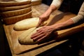 Baker making bread and cutting dough at bakery Royalty Free Stock Photo