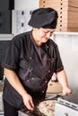 Baker making pizza at the pizzeria kitchen