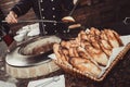 Baker making turkish pita bread in tandoor, clay oven. Baking process. Many fresh hot bread in the basket. Royalty Free Stock Photo