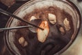 Baker making turkish pita bread in tandoor, clay oven. Baking process. Many fresh hot bread in the basket. Royalty Free Stock Photo