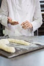 Baker making uncooked dough on tray