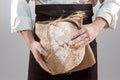 Baker man holding rustic organic loaf of bread in hands