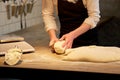 Baker portioning dough with bench cutter at bakery Royalty Free Stock Photo