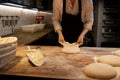 Baker portioning dough with bench cutter at bakery Royalty Free Stock Photo