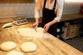 Baker portioning dough with bench cutter at bakery Royalty Free Stock Photo