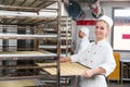 Baker presenting tray with pastry or dough at bakery Royalty Free Stock Photo