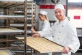 Baker presenting tray with pastry or dough at bakery Royalty Free Stock Photo