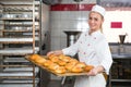 Baker presenting tray with pastry or dough at bakery Royalty Free Stock Photo