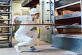 Baker putting bread in the bakery oven Royalty Free Stock Photo