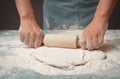 Baker rolls out dough for pizza, flatbread or pastry with rolling pin, prepare ingredients for food, baking for holidays Royalty Free Stock Photo