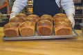 Baker`s hands took the bread from the oven