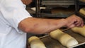 A baker scores raw loaves of sourdough bread