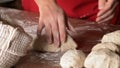 Baker shaping the portioned dough to buns