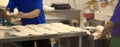 Baker sifting flour through a sieve in bakery shop. Royalty Free Stock Photo