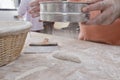 Baker sifts flour over brown bread