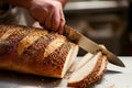 baker slicing bread with a serrated knife Royalty Free Stock Photo