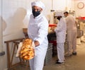 Baker taking baked bread out of oven on wooden shovel Royalty Free Stock Photo