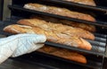 Baker taking a loaf of freshly baked bread from the oven Royalty Free Stock Photo