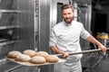 Baker taking out from the oven baked buckweat bread