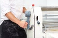 Baker using dough sheeter machine to produce croissants dough at the bakery. Royalty Free Stock Photo
