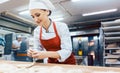 Baker woman forming pretzels and bread