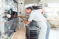 Baker woman getting bread out of bakery oven Royalty Free Stock Photo