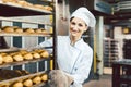 Baker woman pushing sheets with bread in the baking oven Royalty Free Stock Photo