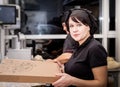 Bakers in black uniform at the pizzeria kitchen working on order