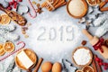 Bakery background with ingredients for cooking decorated with fir tree and new year 2019. Flour, brown sugar, eggs and spices. Royalty Free Stock Photo