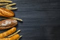 Bakery background top view. Crusty buns and loaves of bread on dark grey chalkboard background