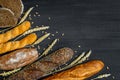 Bakery background top view. Crusty buns and loaves of bread on dark grey chalkboard background