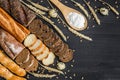 Bakery background top view. Crusty buns and loaves of bread on dark grey chalkboard background