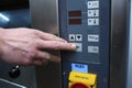 Baker hand pushing a power button on a control panel of an electric oven Royalty Free Stock Photo