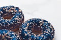 Frosted sprinkled donuts, sweet pastry dessert on marble table background, doughnuts as tasty snack, top view food brand flat lay