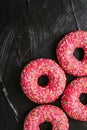 Frosted sprinkled donuts, sweet pastry dessert on rustic wooden background, doughnuts as tasty snack, top view food brand flat lay